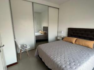 科连特斯Departamento céntrico con cochera - Corrientes Capital的一间卧室配有一张床和镜子