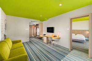 佐洛卡罗斯Park Inn By Radisson Zalakaros Hotel & Spa的酒店客房,设有床铺和绿色天花板