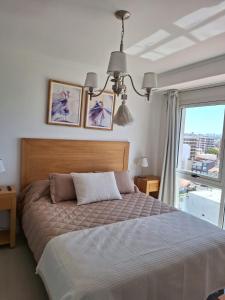 马德普拉塔埃迪菲西奥胡安娜玛尔公寓的一间卧室设有一张大床和一个窗户。