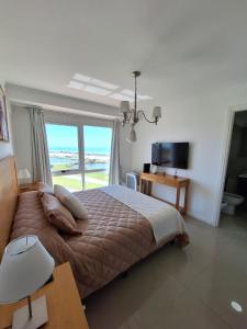 马德普拉塔埃迪菲西奥胡安娜玛尔公寓的一间卧室设有一张床,享有海景