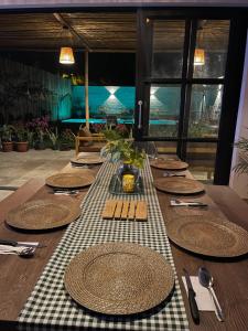 谢内吉亚区Hermosa casa de campo con piscina en Cieneguilla的一张木桌,上面有盘子和餐具