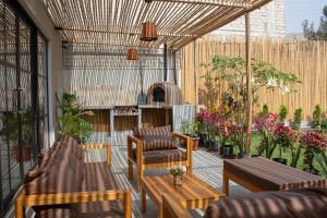 谢内吉亚区Hermosa casa de campo con piscina en Cieneguilla的带沙发、椅子和植物的天井