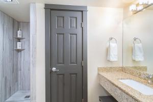 特柳赖德Mountainside Inn 419-21 Hotel Room的浴室设有门、水槽和镜子