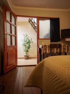 波托西Los Faroles Hostal的一间卧室配有一张床和盆栽植物