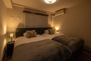 大阪Crest Otemae Stay - Self Check-In Only的一间卧室配有一张大床和两个枕头