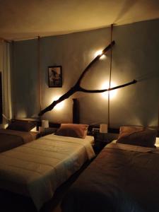 瓦迪穆萨Petra Musa Rural House的一间设有两张床的房间,墙上有一条树枝
