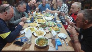 吉仙绿竹苑度假村的一群坐在桌子旁吃食物的人