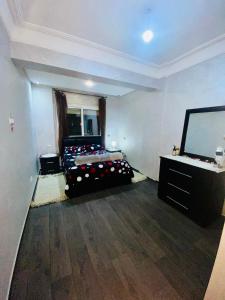 卡萨布兰卡Appartement de lux的客房设有一张床和一台平面电视。