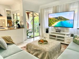 Cairns NorthLuxury 2 Bedroom apartment, Treetop views, Resort with 4 swimming pools的客厅设有壁挂式平面电视。