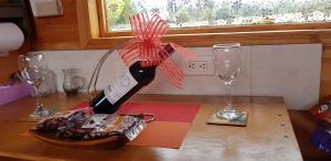 瓜斯卡Cabaña Los Linos的桌子上一瓶葡萄酒和两杯