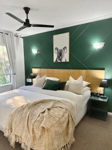 Cairns NorthLuxury tropical 2bedroom apartment in resort 4 swimming pools的一间卧室设有一张大床和绿色的墙壁
