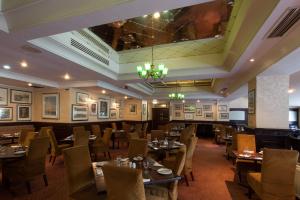 伦敦大不列颠汉普斯蒂德酒店的一间带桌椅和吊灯的用餐室