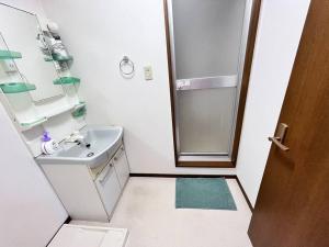 大阪日本橋電気街　DenDenTown大面積40㎡工レベ-タ-直結5F的白色的浴室设有水槽和淋浴。