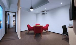 诗都阿佐NEO+Waru-Sidoarjo by ASTON的一间用餐室,配有红色的椅子和桌子