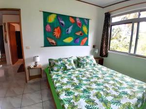 PareaCHEZ VAIANA的一间卧室配有一张带五颜六色棉被的床