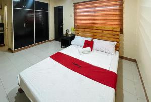 达沃市RedDoorz @ Cion Suites Mintal Davao的一间卧室配有一张大床和木制床头板