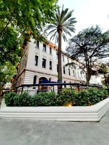布宜诺斯艾利斯Departamento en Palermo Hollywood的一座白色的建筑,前面有棕榈树