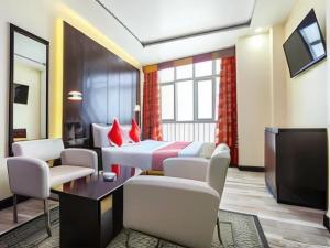 富查伊拉SHH Hotel的一间酒店客房,设有两张床和电视