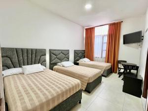波帕扬Hotel Dorado Real HDR的酒店客房设有两张床和电视。