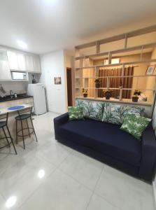 奥林匹亚Flat Brilho do Sol的一间带蓝色沙发的客厅和一间厨房