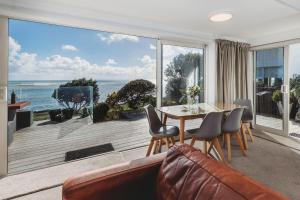 新普利茅斯Te Moana Waterfront的客厅配有桌子,享有海景