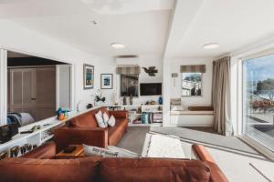 新普利茅斯Te Moana Waterfront的客厅配有2张棕色皮沙发