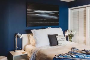 新普利茅斯Te Moana Waterfront的卧室拥有蓝色的墙壁和一张床