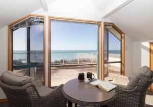 新普利茅斯Beachfront Bliss On Wanaka Terrace Support Local的海景客房 - 带桌椅
