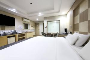 釜山Q5 Hotel Busan Songdo的酒店客房设有一张大床和一个厨房。