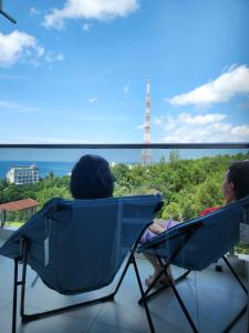富国Mi Amor Luxury Island Apartment - 3 minutes to the beach的两个人坐在椅子上,望着大海
