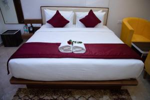 耶拉汉卡Hotel Grand Villa的一间卧室配有一张带红色枕头的大床