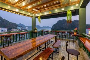 吉婆岛Aroma Cat Ba Sea View Hotel的阳台餐厅配有木桌和椅子
