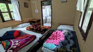柴尔Hail Himalayas的带三张床的客房,设有浴室