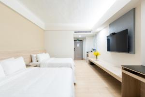 台中市怡东商务旅馆的酒店客房设有两张床和一台平面电视。