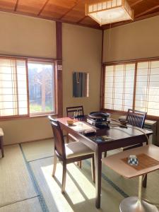 藏王温泉吉田屋旅馆的一间带桌椅和窗户的用餐室