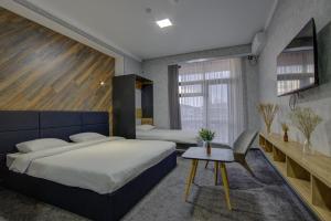 博斯特里Vzmorie Resort Hotel的一间卧室配有两张床和一张桌子