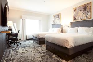 休斯顿Champions Club Texas的酒店客房设有两张床、一张书桌和一个窗户。