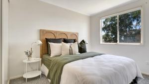 麦夸里港Camp Jordan的白色卧室设有一张大床和窗户