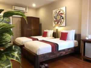 清迈松格兰之家酒店的一间酒店客房,配有两张床和植物