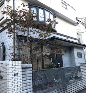 东京冠京ホテル的前面有一棵树的白色砖屋