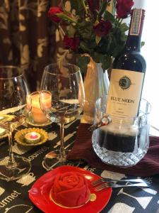 清迈松格兰之家酒店的一张桌子,上面放着一瓶葡萄酒和一个红盘