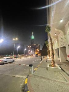 麦加Nawazi Towers Hotel的城市街道,晚上有绿灯的建筑