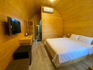 Kon PlongKhách Sạn Măng Đen Xanh的木制客房内的一间卧室,配有一张床