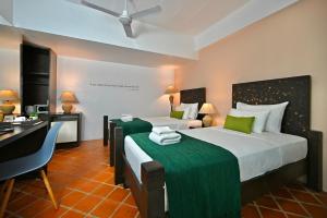 卡马拉海滩爬爬螃蟹精品旅馆的酒店客房设有两张床、一张书桌和一个厨房。