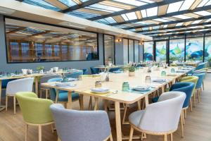 奈通海滩Wyndham Garden Naithon Phuket的用餐室设有桌椅和窗户。