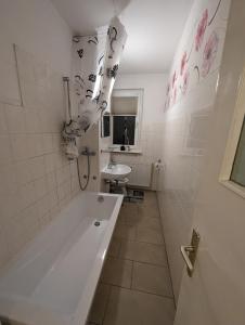 新勃兰登堡NB Vogelviertel zwei Zimmer Wohnung的白色的浴室设有浴缸和水槽。