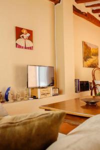 巴涅雷斯德马里奥拉EL TEULAR DE CARMEN的客厅配有平面电视和桌子。