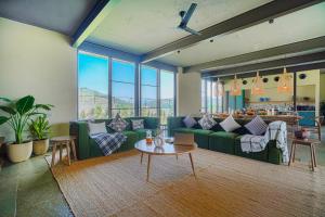 乌代浦SaffronStays Villa Rohi的客厅配有绿色沙发和桌子