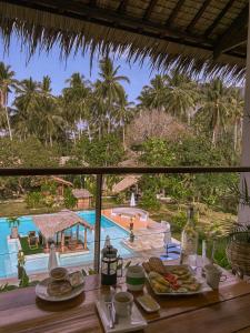 爱妮岛El Nido Moringa Resort的餐桌,享有泳池美景