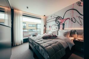 赫尔辛基Hotel AX的卧室配有一张大床,墙上挂有绘画作品